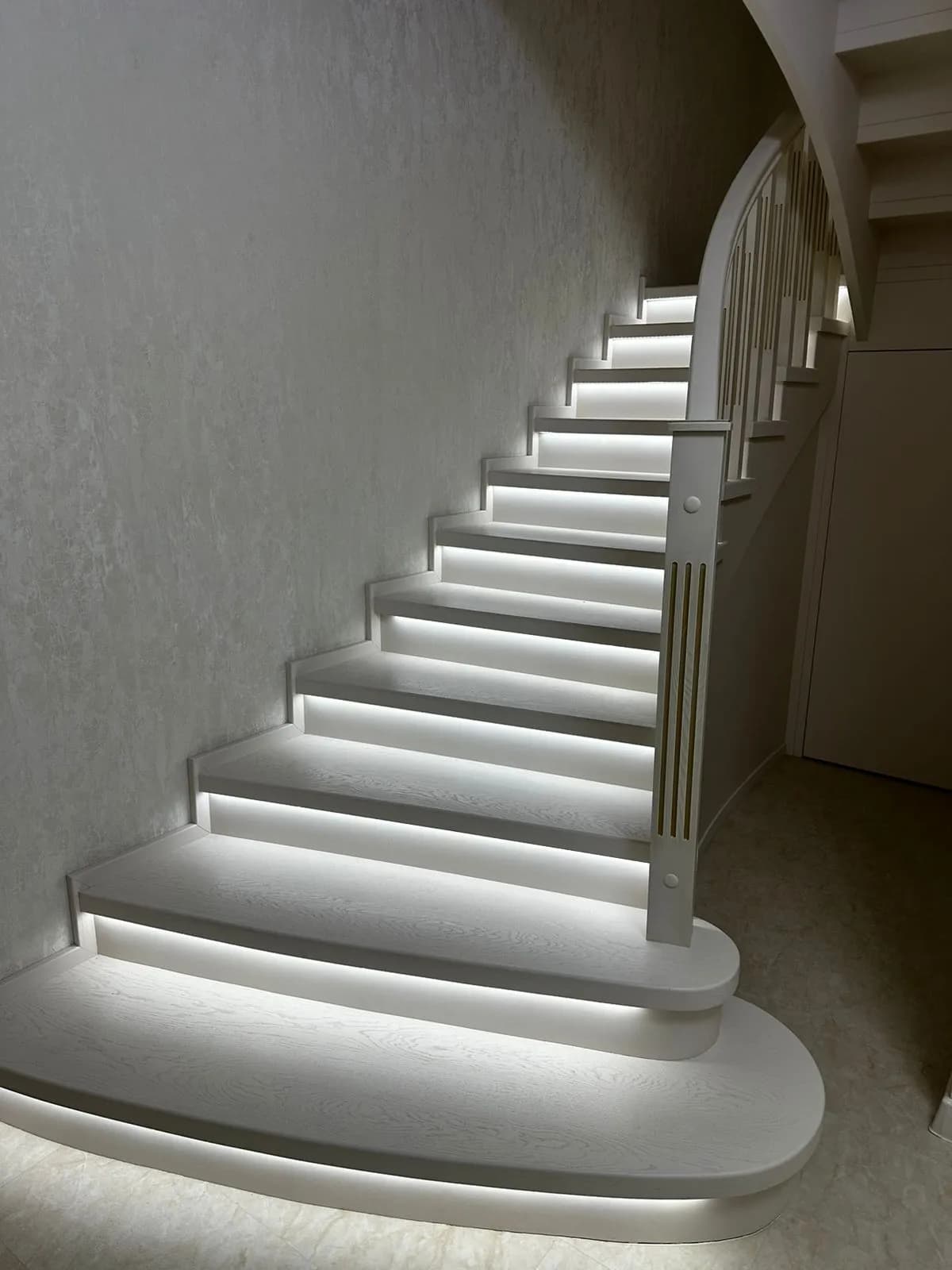 Встроенная подсветка под ступенями в вечернем интерьере дома