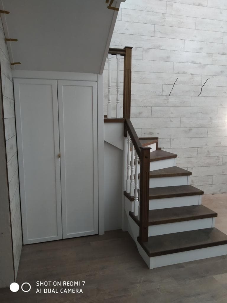 Под лестницей обустроена кладовая с дверцами