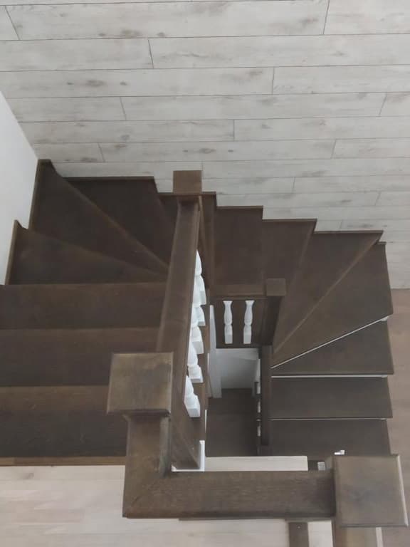 Вид со второго этажа на забежные ступени лестницы из березы