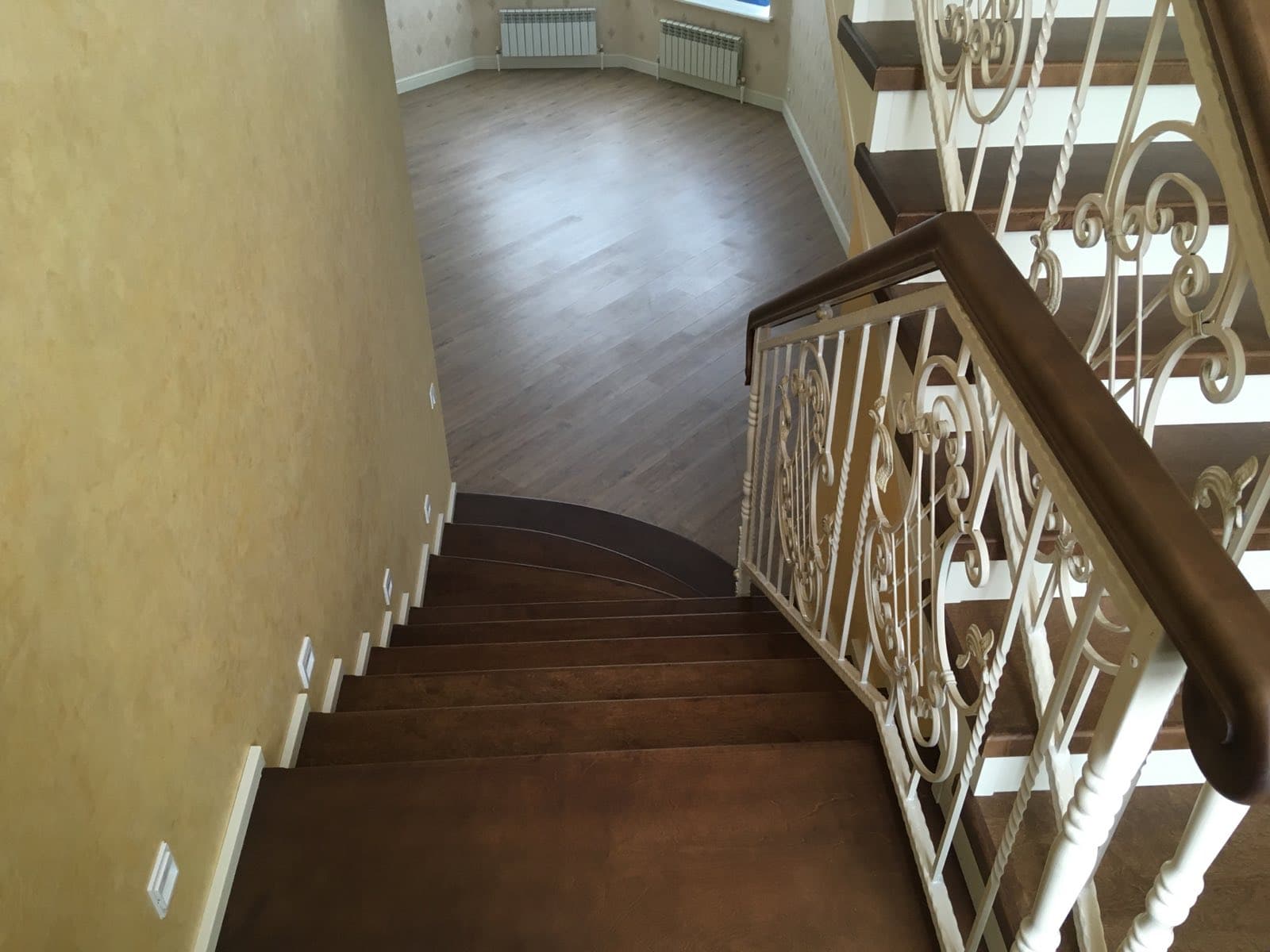 Широкая поворотная площадка на бетонной лестнице в коттедже