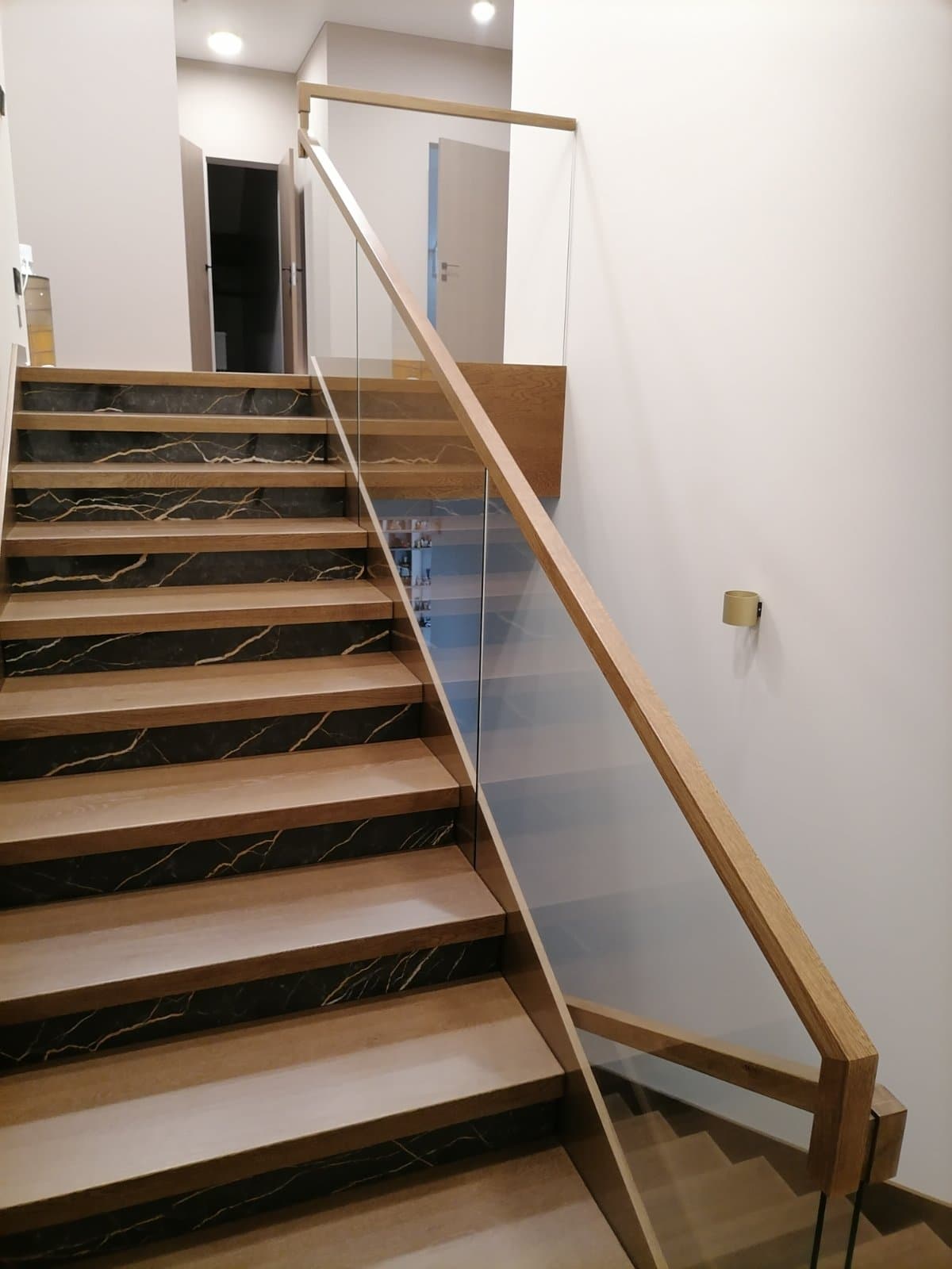 Сочетание умной подсветки лестницы под ступенями и настенными фонарями