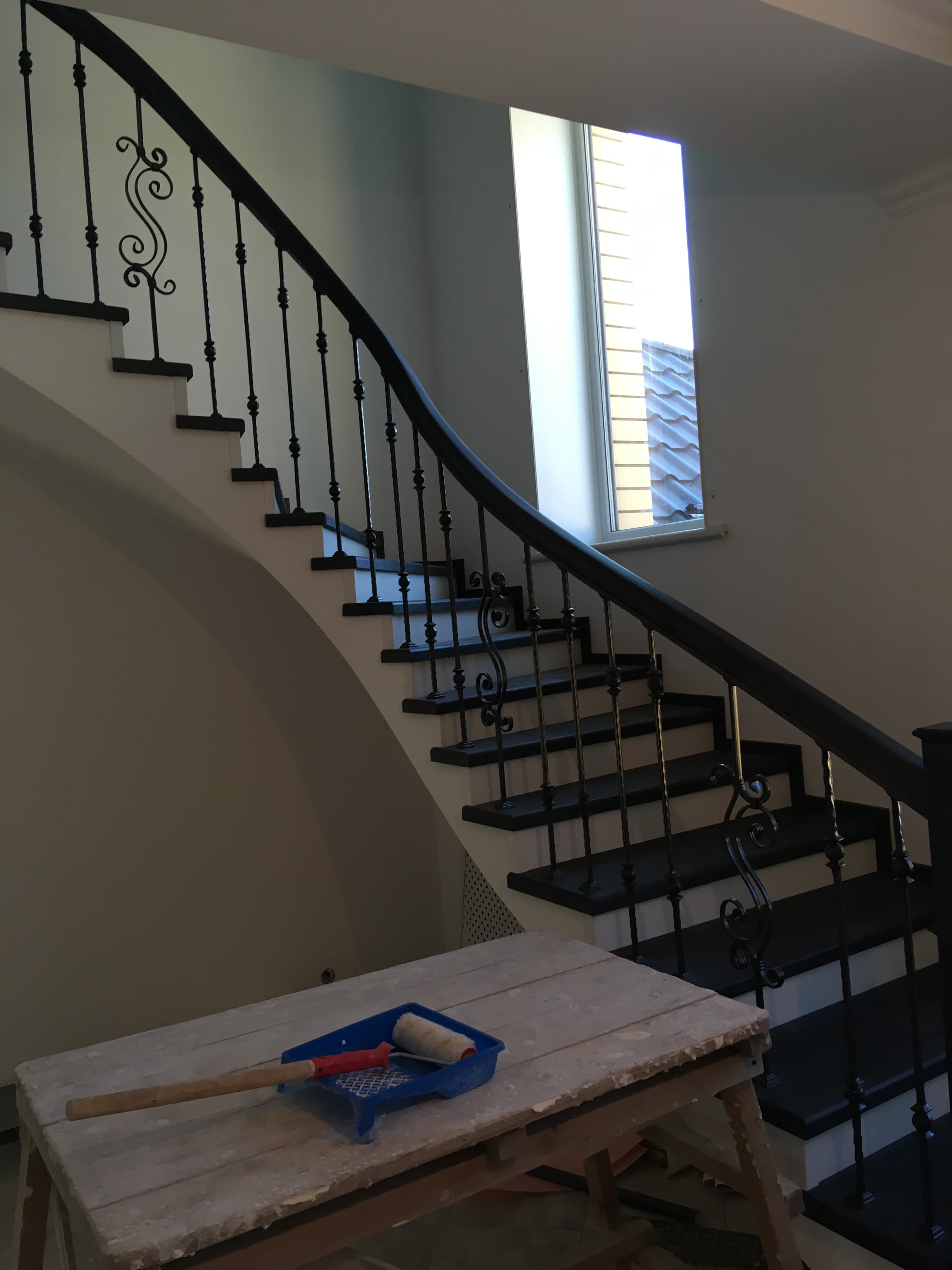 Вид на бетонную лестницу и изогнутый поручень сбоку