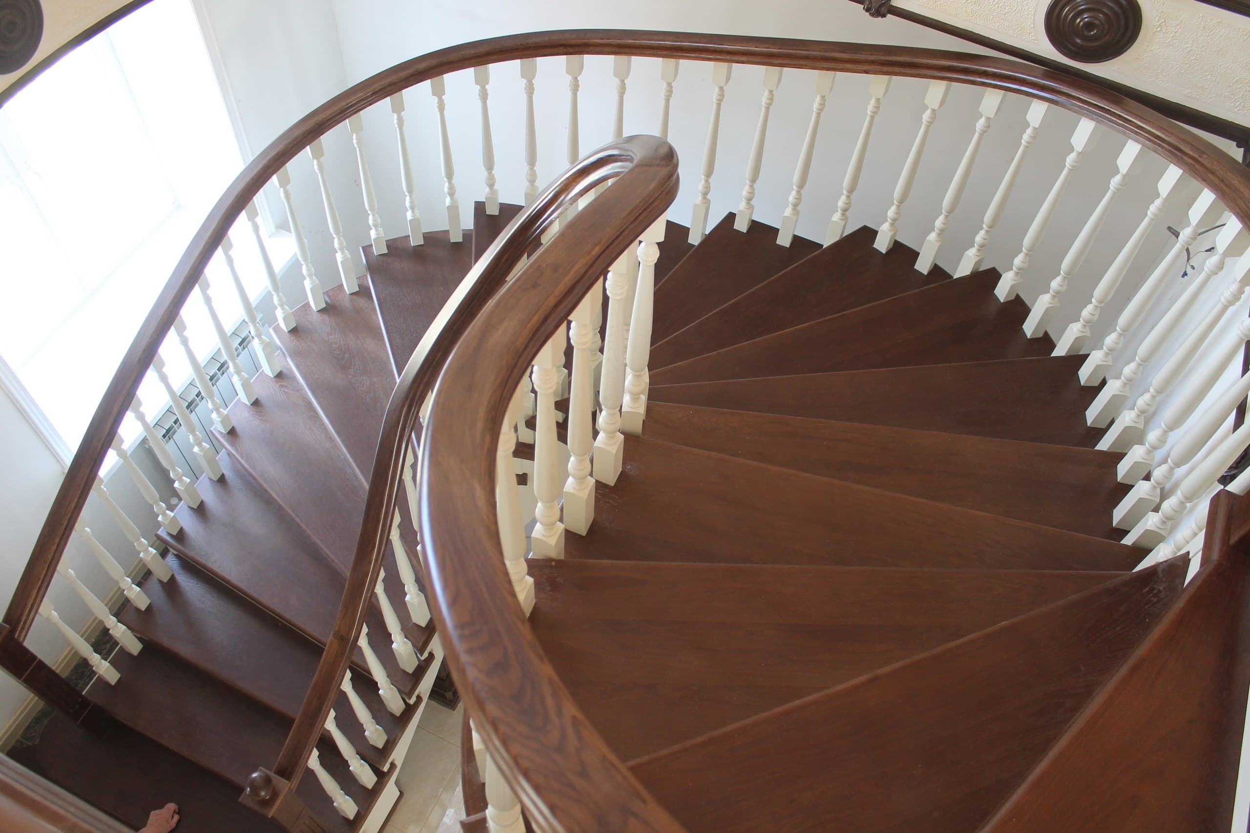 Изгибы поручня полувинтовой дубовой лестницы