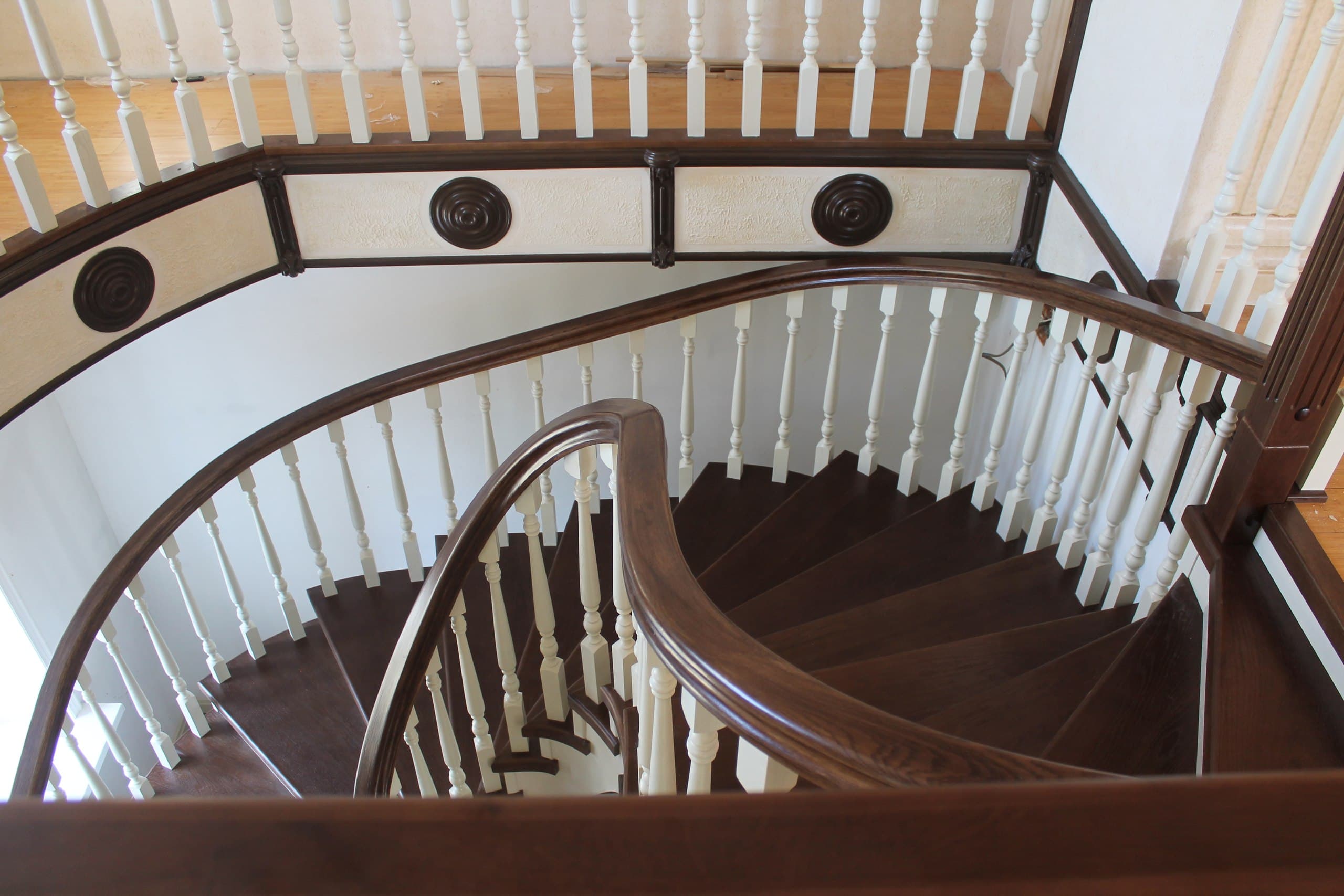 Вид со второго этажа на изгибы лестницы в доме