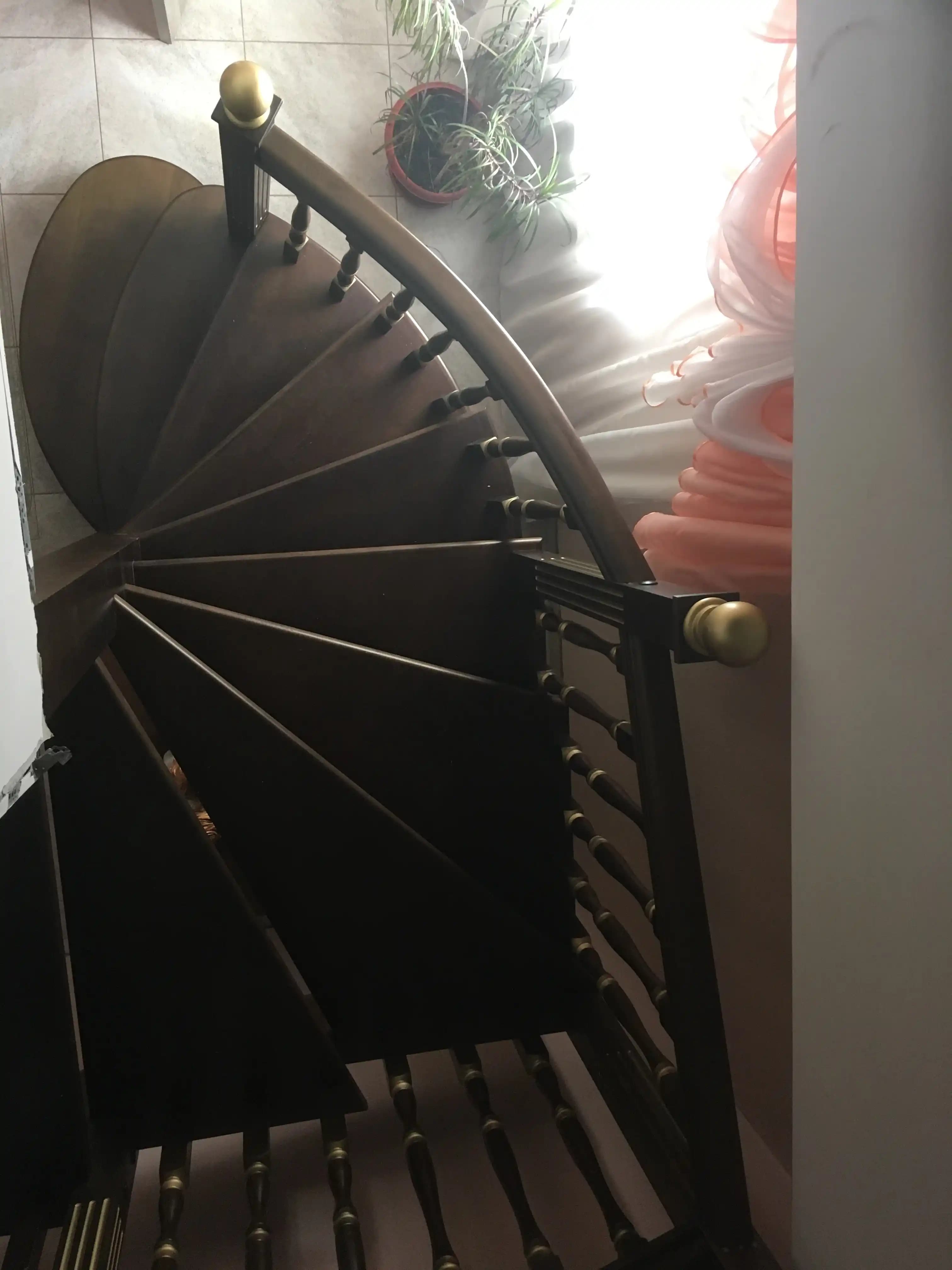 Вид сверху на забежные ступени из массива и изгиб лестницы