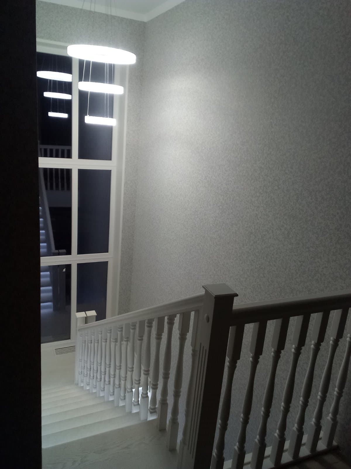 Верхнее ограждение разворотной лестницы с подсветкой на втором этаже