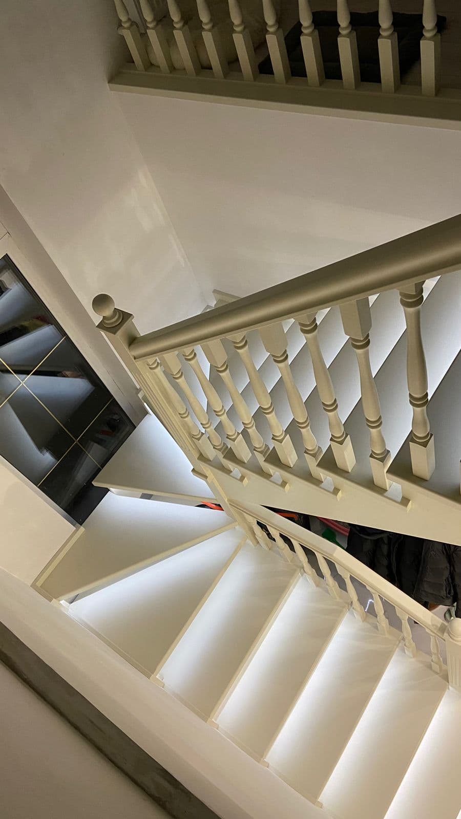 Лестница на второй этаж в отделке из белой эмали с включенной подсветкой