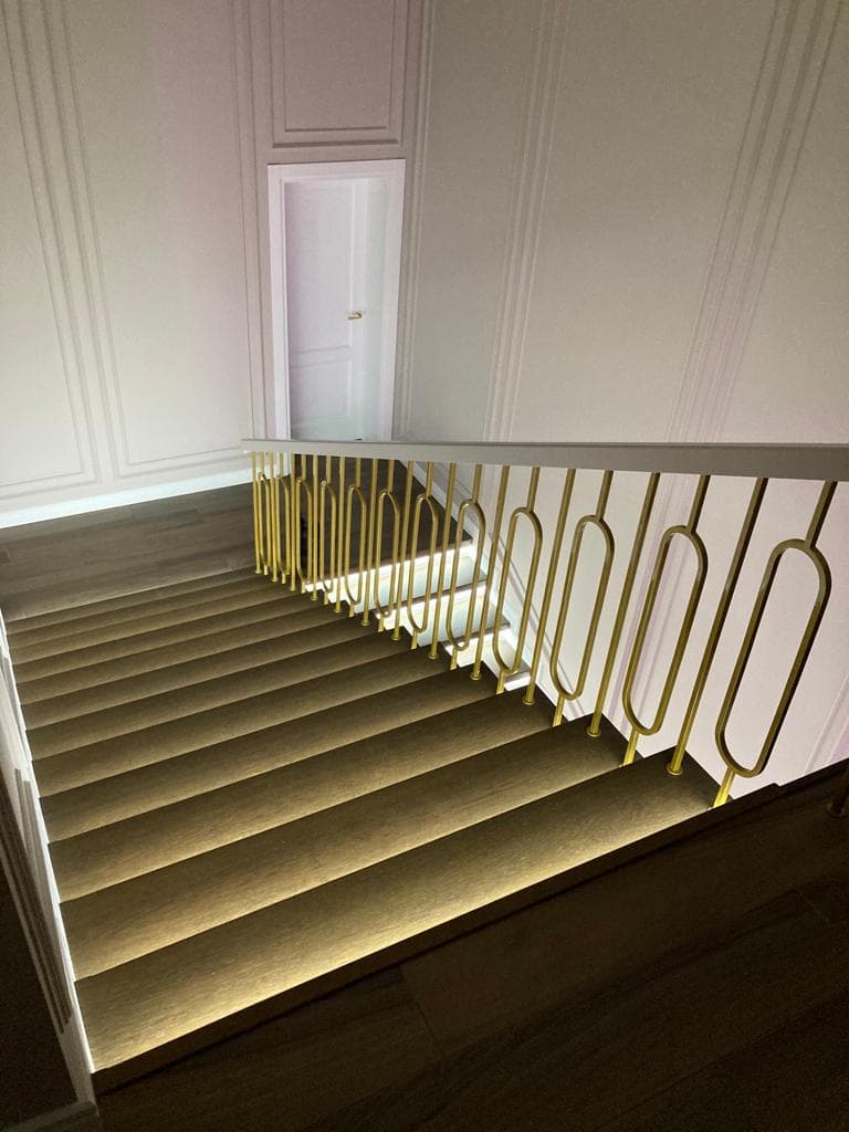 Вид со второго этажа на марши лестницы с подсветкой