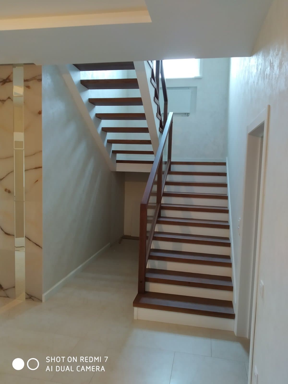 Современная лестница с площадкой выглядит просто и элегантно в богатом интерьере дома