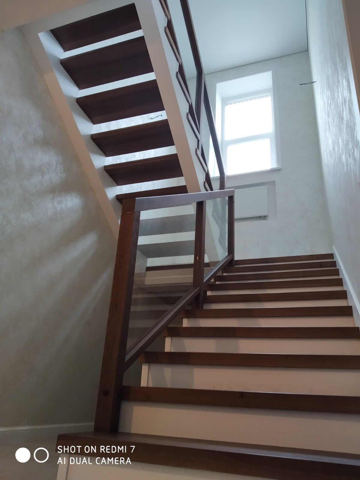 Четкие линии современной лестницы со стеклянными ограждениями