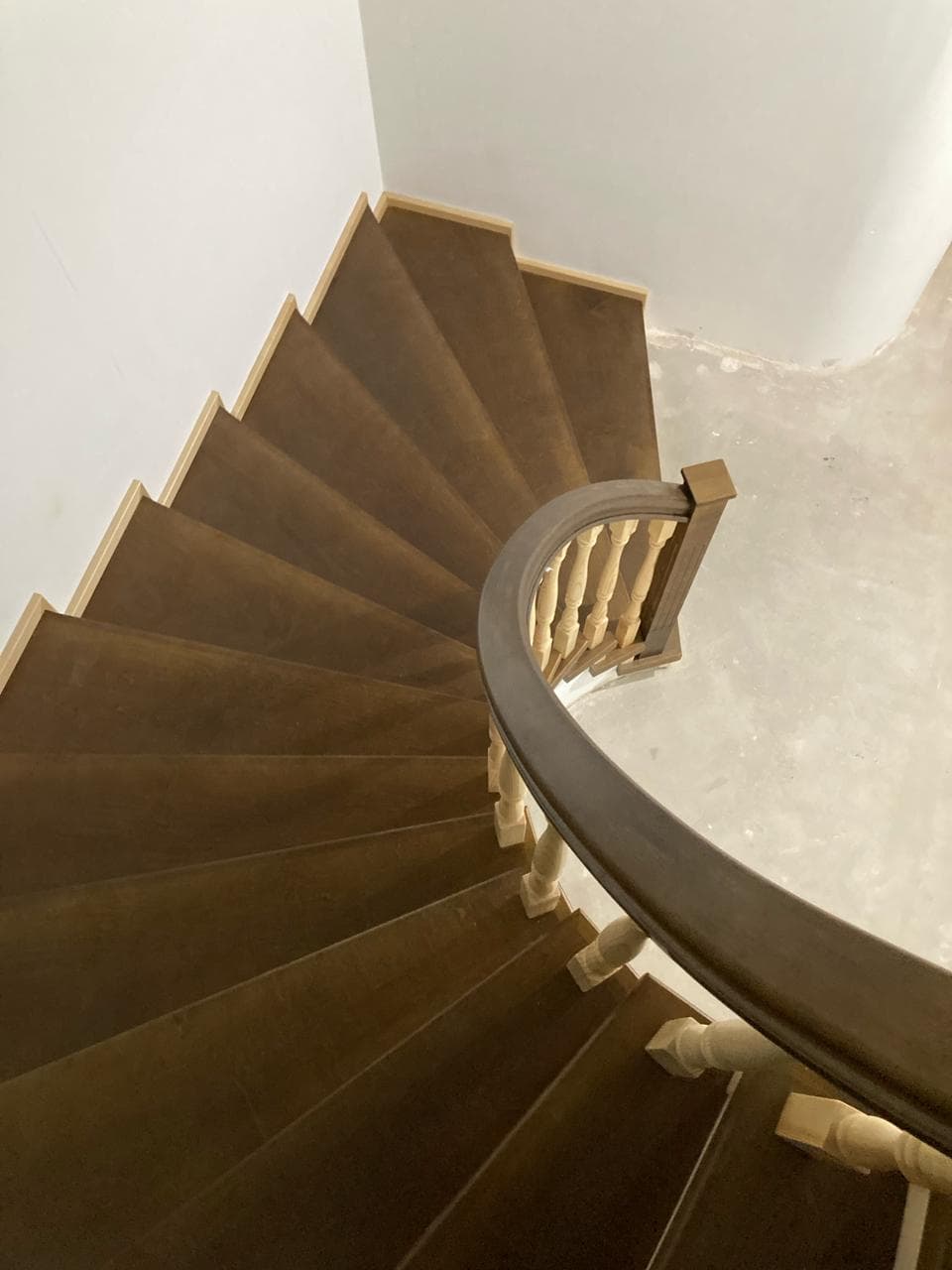 Плавный изгиб поручня на бетонной лестнице в доме