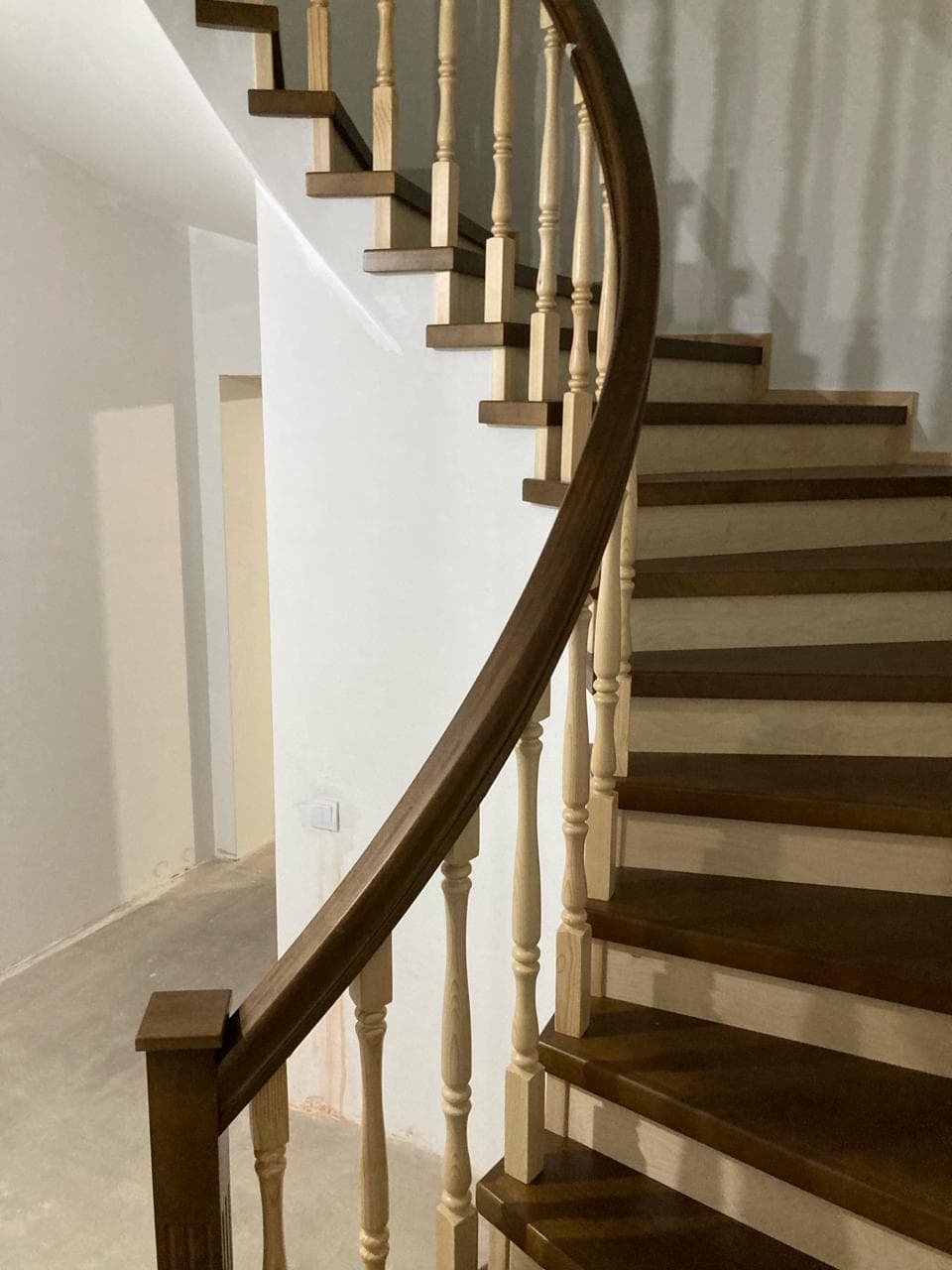 Вид на изгибы лестницы на бетонном основании с забежных ступеней